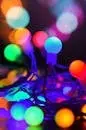 A close-up of colorful glowing Christmas string lights with a bokeh effect, perfect for festive celebrations.
