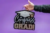 Celebrate graduation with a striking 'Congrats Grad!' sign against a vibrant purple backdrop.